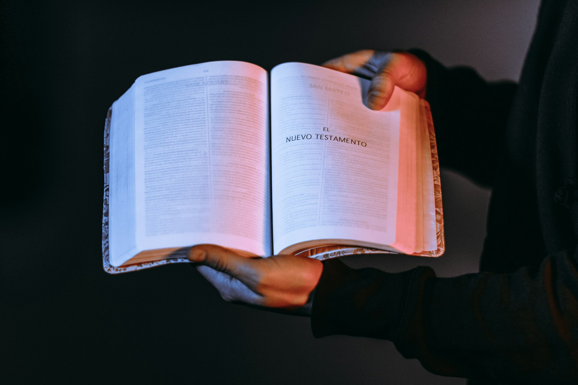 person holding book showing Nuevo Testamento
